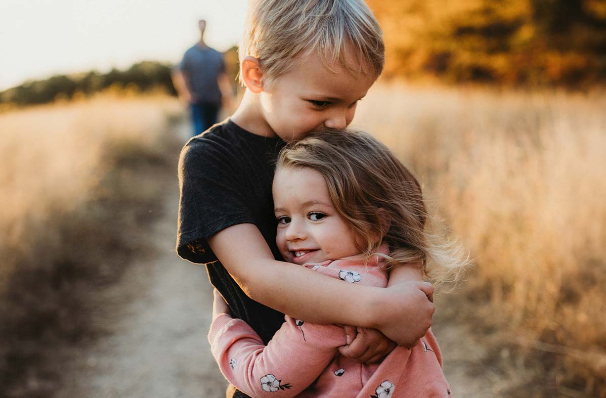 spokane-Insurance-Local-family little kids hugging each other with parent walking behind
